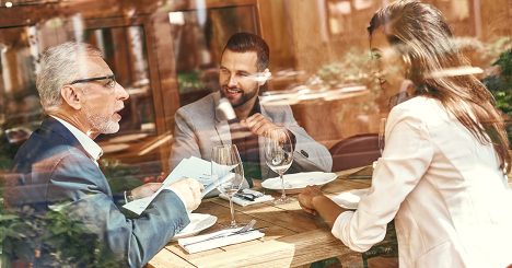 Three People At Lunch Meeting Looking Through Window