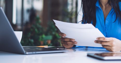 Womans Hands Holding Paper And Laptop