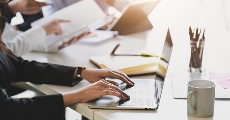 Workers At Desk On Laptop