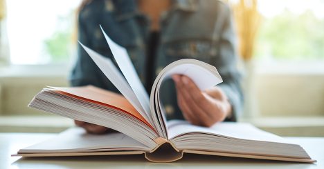 Woman Flipping Through Large Book