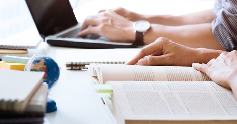 Hands With Textbooks And Laptop