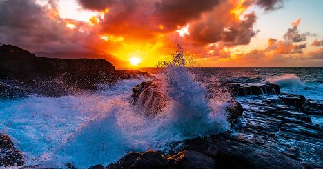 Waves Crashing On Rocks In Front Of Sunset