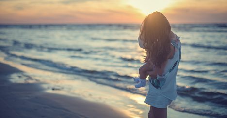 Woman With Baby From Behind On Beach