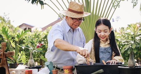 Old Man Gardening With Granddaughter