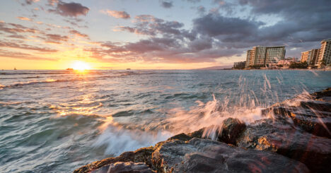 Waves Hitting Rocks In Sunset With Waikiki Background View
