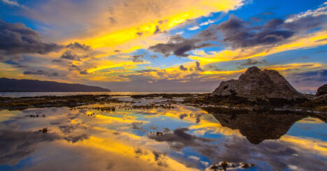 Large Rocks Reflecting On Ocean In The Sunlight